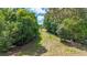 The backyard boasts a mowed grassy path that climbs uphill, flanked by trees lining the yard's perimeter at 104 Meadow View Trl, Canton, GA 30115