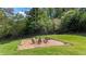 Large backyard features a mulched seating area with chairs, a table, and a black fence at 104 Meadow View Trl, Canton, GA 30115