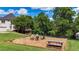 Backyard fire pit area with picnic table, surrounded by manicured lawn and mature trees, perfect for outdoor gatherings at 104 Meadow View Trl, Canton, GA 30115