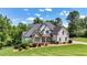Beautiful home featuring a stone and painted facade, professional landscaping, and a sprawling green lawn at 104 Meadow View Trl, Canton, GA 30115