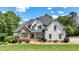 Stunning two-story home with a stone facade, lush landscaping, and a welcoming front porch at 104 Meadow View Trl, Canton, GA 30115