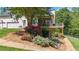 Landscaped backyard with flower beds and an elevated wooden deck with a screened in porch at 104 Meadow View Trl, Canton, GA 30115