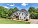 Attractive home with painted facade and stone accents complemented by a well-manicured lawn and mature trees at 104 Meadow View Trl, Canton, GA 30115