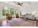 Bright living room features large windows, hardwood floors, a ceiling fan and comfortable seating arrangements at 104 Meadow View Trl, Canton, GA 30115