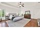 Bright main bedroom boasting hardwood floors, tray ceiling, and multiple windows with plantation shutters at 104 Meadow View Trl, Canton, GA 30115