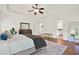 A well-lit main bedroom with hardwood floors, a tray ceiling, ceiling fan and a glimpse into the bathroom at 104 Meadow View Trl, Canton, GA 30115