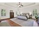 Spacious main bedroom featuring hardwood floors, tray ceiling, ceiling fan and lots of windows at 104 Meadow View Trl, Canton, GA 30115