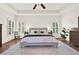 A spacious main bedroom featuring hardwood floors, tray ceilings, and a ceiling fan, illuminated by natural light at 104 Meadow View Trl, Canton, GA 30115