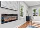 Close up view of a fireplace with modern art, hardwood flooring, and view through the windows at 2205 Stockbridge Se Dr, Atlanta, GA 30316