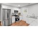 Well-lit kitchen featuring stainless steel appliances, white cabinetry, granite countertops, and hardwood flooring at 2205 Stockbridge Se Dr, Atlanta, GA 30316