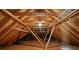 Exposed attic with wooden rafters and crossbeams, enhanced by industrial lighting at 1019 Henna Se Ct, Conyers, GA 30013
