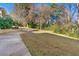 View of a spacious backyard with driveway, surrounded by mature trees and lush greenery at 1019 Henna Se Ct, Conyers, GA 30013