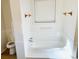 Clean bathroom featuring a white tub and tile surround with a window at 1019 Henna Se Ct, Conyers, GA 30013
