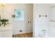 Bright bathroom with a white vanity, a gold faucet and a window view, and a bathtub with a faucet at 1019 Henna Se Ct, Conyers, GA 30013