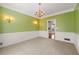 Formal dining room features traditional wainscoting, chandelier, and neutral carpet at 1019 Henna Se Ct, Conyers, GA 30013