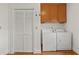 Functional laundry room with washer, dryer, closet, and storage cabinets at 1019 Henna Se Ct, Conyers, GA 30013