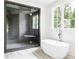Spa-like bathroom featuring a freestanding tub, a spacious shower with a glass enclosure, and serene natural light at 1211 Reeder Ne Cir, Atlanta, GA 30306