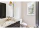 Stylish powder room features dark cabinets, a marble countertop, gold fixtures, and modern lighting at 1211 Reeder Ne Cir, Atlanta, GA 30306