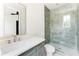 Modern bathroom with a glass shower, and gray tile, complemented by sleek fixtures and lighting at 1211 Reeder Ne Cir, Atlanta, GA 30306