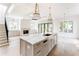 Open-concept kitchen features a large marble island, stainless steel appliances, and an adjacent living area at 1211 Reeder Ne Cir, Atlanta, GA 30306