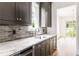 Modern kitchen features dark cabinets, a marble countertop, stainless steel appliances, and hardwood floors at 1211 Reeder Ne Cir, Atlanta, GA 30306