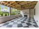 Covered outdoor space featuring a brick fireplace, ceiling fan and black and white tile floors at 1211 Reeder Ne Cir, Atlanta, GA 30306