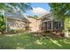 Back exterior with brick, screened porch, a patio, and a lush, green yard at 3134 Hudson Pond Ln, Marietta, GA 30062