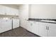 Well-equipped laundry room featuring a washer, dryer, sink, and storage cabinets at 3134 Hudson Pond Ln, Marietta, GA 30062