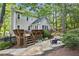The backyard features a spacious deck, stone pathway, and patio with seating, surrounded by lush greenery at 3298 Robinson Oaks Ne Way, Marietta, GA 30062