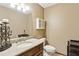Well-lit half-bath featuring granite countertop, wood cabinetry, and decorative accents at 3298 Robinson Oaks Ne Way, Marietta, GA 30062