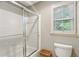 Bright bathroom featuring a shower with glass doors, a window with shutters, and a convenient toilet at 3298 Robinson Oaks Ne Way, Marietta, GA 30062