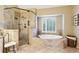 Elegant bathroom featuring walk-in shower, soaking tub, and a large window with plantation shutters at 3298 Robinson Oaks Ne Way, Marietta, GA 30062