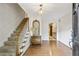 Welcoming foyer featuring hardwood floors, a staircase, and a decorative mirror, creating a warm entry at 3298 Robinson Oaks Ne Way, Marietta, GA 30062