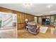 A spacious living room offers a blend of traditional wood panels and large TV for modern entertainment at 3298 Robinson Oaks Ne Way, Marietta, GA 30062