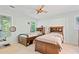 Bright bedroom featuring two twin beds, ceiling fan and natural light from the windows at 710 Leeds Garden Ter, Alpharetta, GA 30022