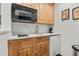 Functional kitchenette with white countertops, wooden cabinets, and modern appliances at 710 Leeds Garden Ter, Alpharetta, GA 30022