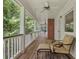 Covered porch with comfortable seating and views of mature trees at 710 Leeds Garden Ter, Alpharetta, GA 30022