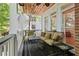 Covered porch with comfortable seating and a view of the surrounding trees at 710 Leeds Garden Ter, Alpharetta, GA 30022
