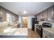 Spacious kitchen featuring gray cabinets, granite countertops, and stainless steel appliances at 7156 Whitfield Dr, Riverdale, GA 30296
