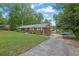 Brick home with a long driveway offering ample parking space surrounded by green lawn and mature trees at 1192 Pathfinder Rd, Marietta, GA 30066
