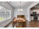 Elegant dining room with natural light, modern chandelier, decorative wall paneling, and adjacent access to kitchen at 209 Shelton Cir, Temple, GA 30179