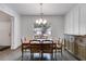 Bright dining room featuring wood flooring, wainscotting, a traditional table set, and a stylish light fixture at 209 Shelton Cir, Temple, GA 30179