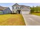 Charming two-story home featuring a gray exterior, manicured lawn, and a concrete driveway leading to a two-car garage at 209 Shelton Cir, Temple, GA 30179