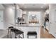 Bright kitchen features an island with bar seating, white cabinets, stainless steel appliances, and an adjacent dining area at 209 Shelton Cir, Temple, GA 30179