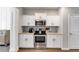 Well-equipped kitchen featuring stainless steel appliances, white cabinetry, and elegant hardwood floors for a modern feel at 209 Shelton Cir, Temple, GA 30179