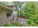 A wooded backyard with a brick house and a patio at 2288 Hudson Sw Dr, Lilburn, GA 30047