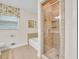 Bathroom with shower, white tub, tile floors, and window with patterned curtain at 2288 Hudson Sw Dr, Lilburn, GA 30047