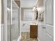 Bathroom with a shower featuring clear glass doors, patterned floors, and small vanity at 2288 Hudson Sw Dr, Lilburn, GA 30047