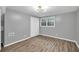 Bedroom with grey walls, light-colored floors, a double closet, and modern light fixture at 2288 Hudson Sw Dr, Lilburn, GA 30047