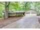 Charming home exterior with mature trees, a long driveway, and a convenient two-car garage at 2288 Hudson Sw Dr, Lilburn, GA 30047